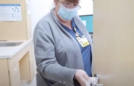 APD staff member cleaning a door knob