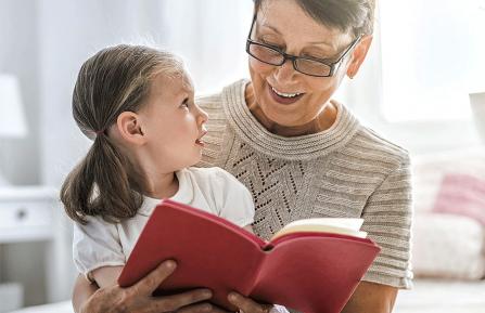 Woman reading a book to a little girl